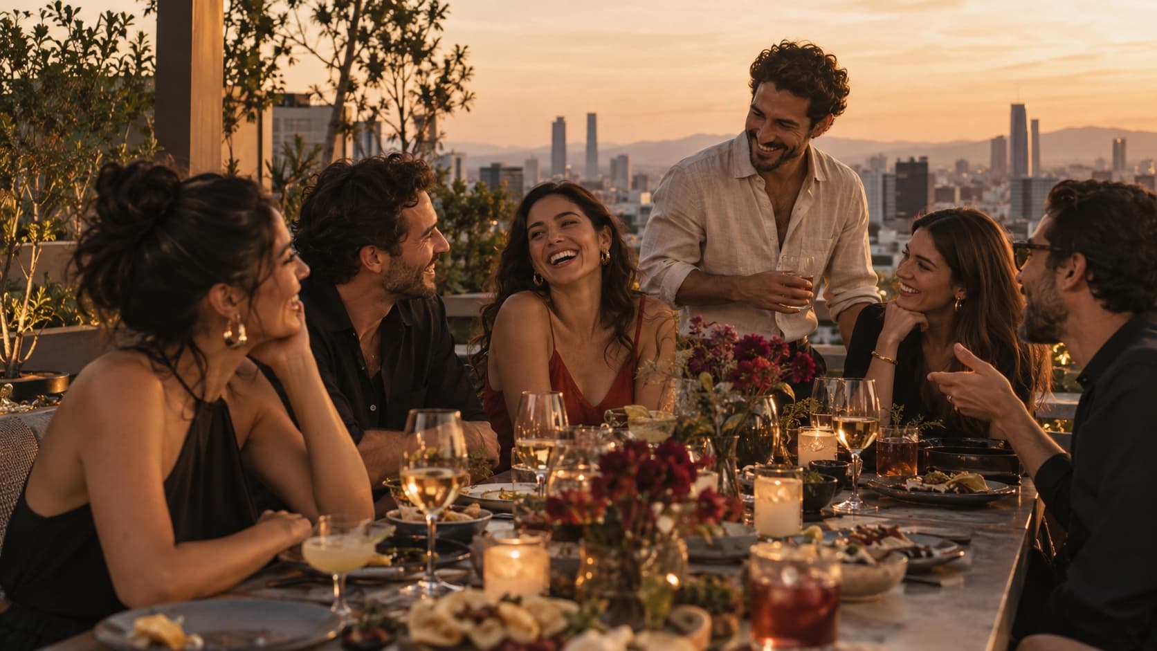 A group of people share dinner at sunset on a Mexico City rooftop.